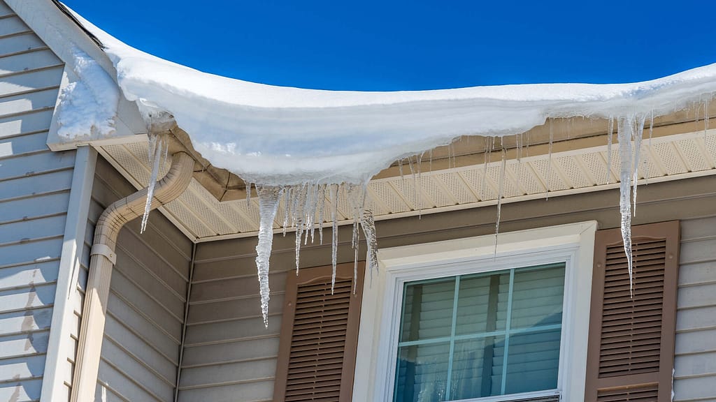 Ice dam on roof covered with snow