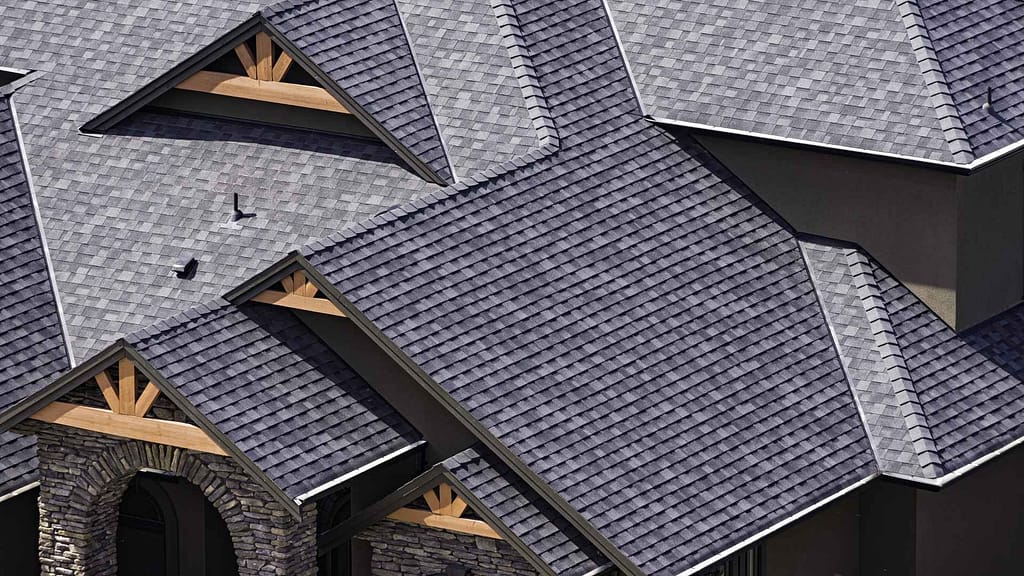 A complex dimensional asphalt shingle roof with multiple doormers