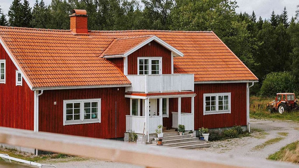 A cute cross gable roof home with red tile roof