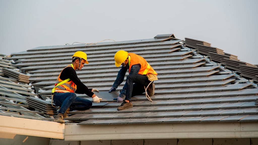 Two workers doing roof installation