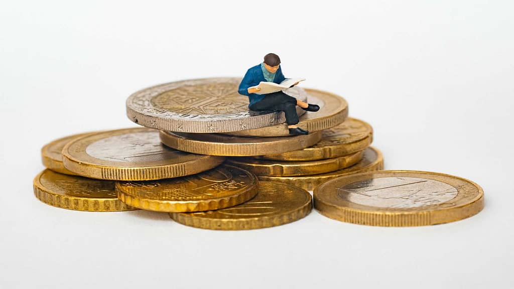 person reading on top of money coins about Utah roof replacement cost