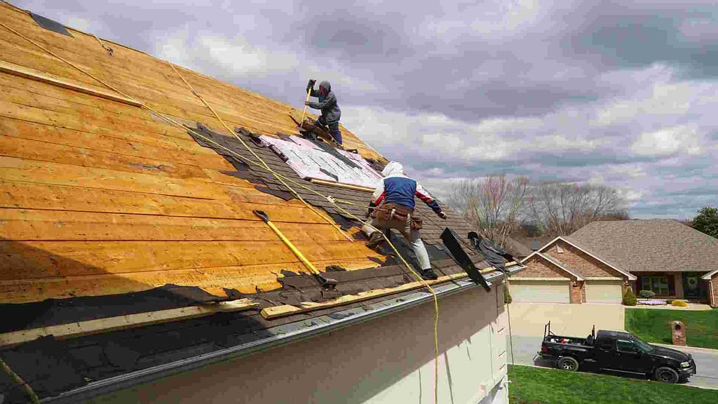 two men working at the top of the roof after using our Delaware roofing calculator