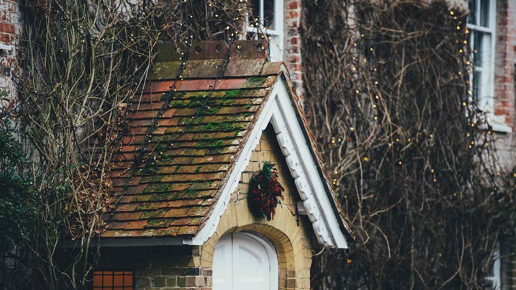 faded old roof with moss subjected to North Carolina new roof cost estimation