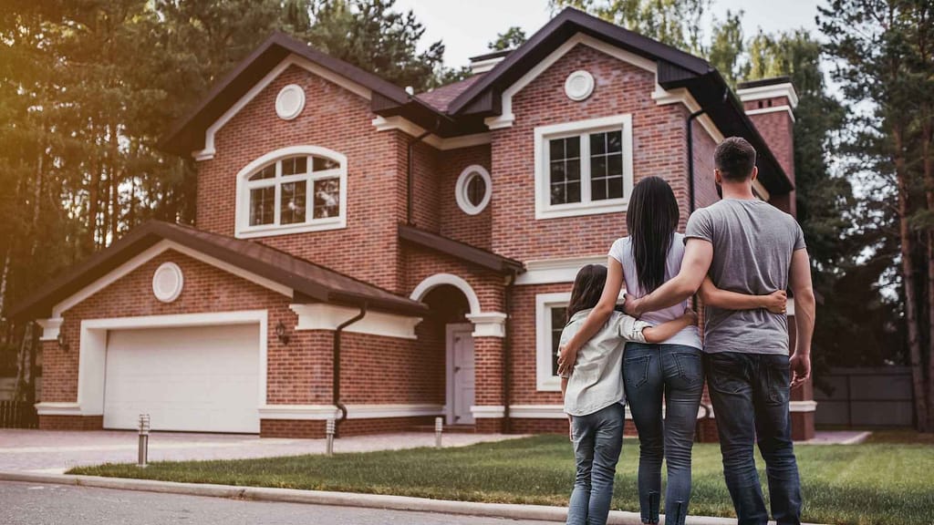 Family standing in front of their home with a new roof.