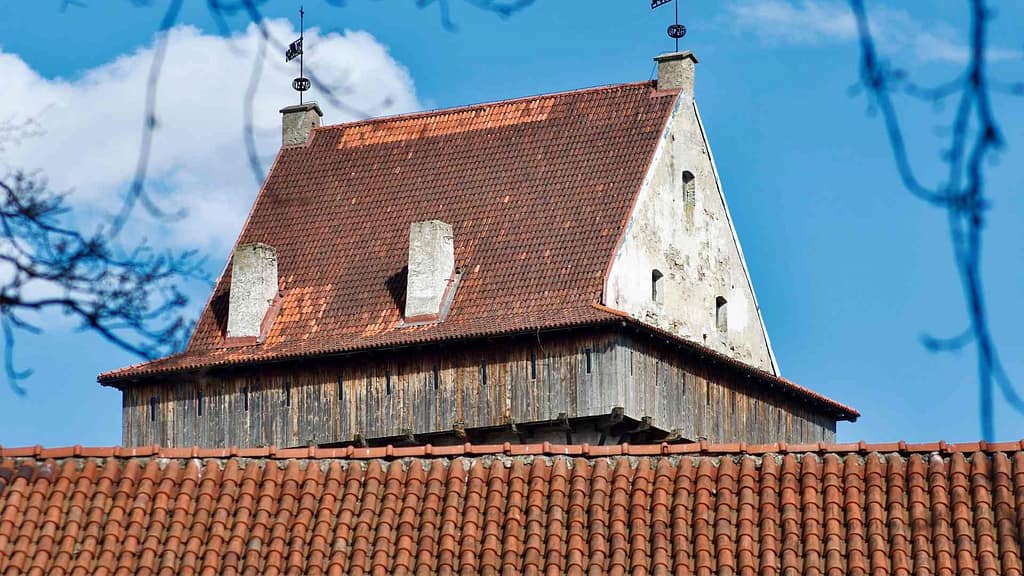 old and faded roof with chimneys subject to Illinois new roof cost estimation