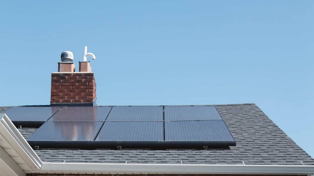 gray roof with chimney and solar panel from Tennessee roofing contractor