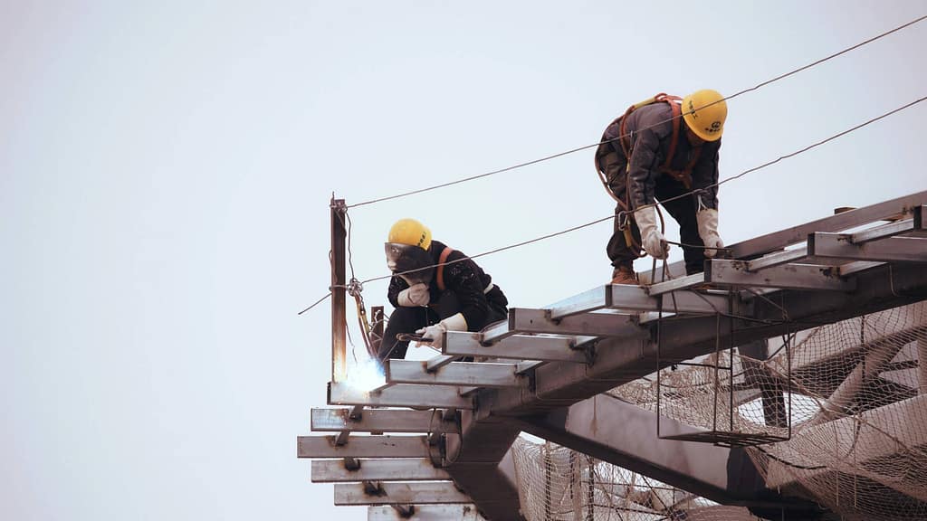 two roofers from Alaska roofing contractor in yellow hard hat