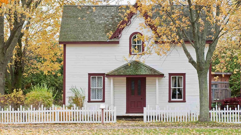 home surrounded by trees with old roof with moss inspected by a New York roofer