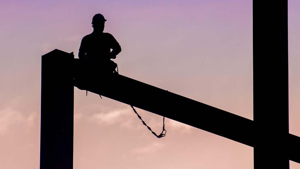 worker silhouette over pink sky