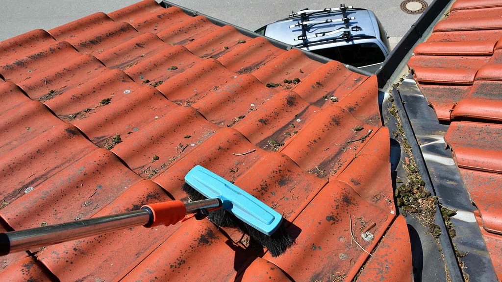 cleaning a metal roof with a brush