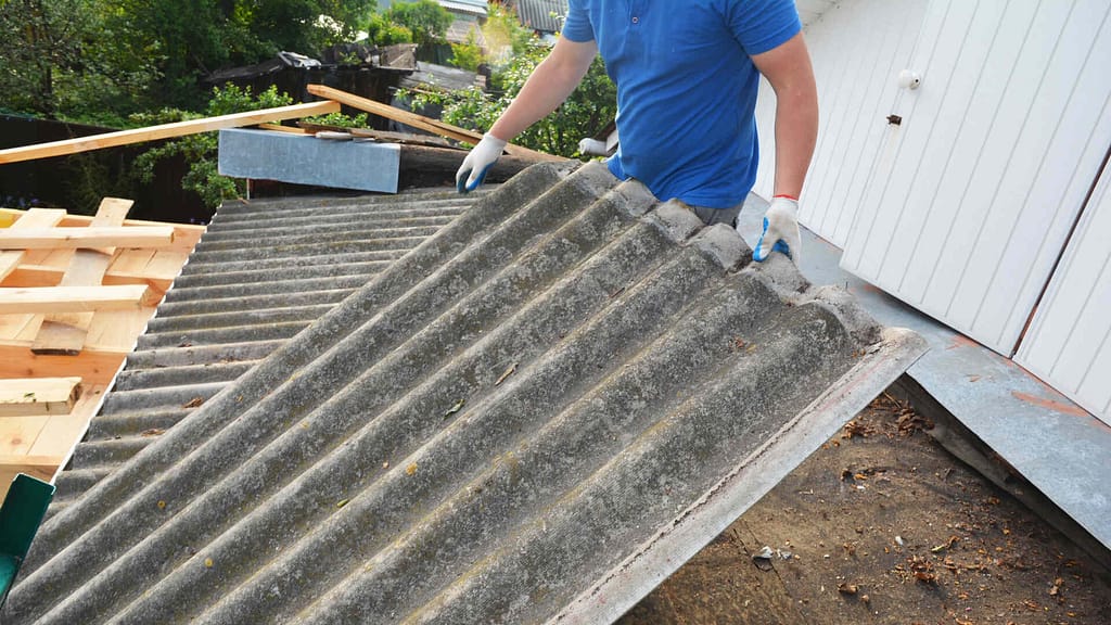 Person cleaning and removing old roof