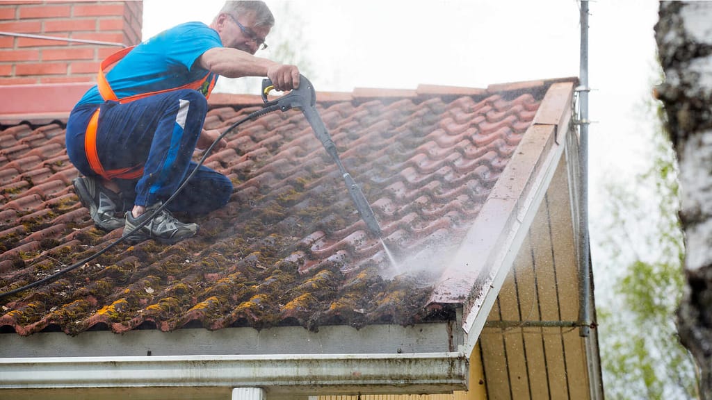 Person rinsing roof