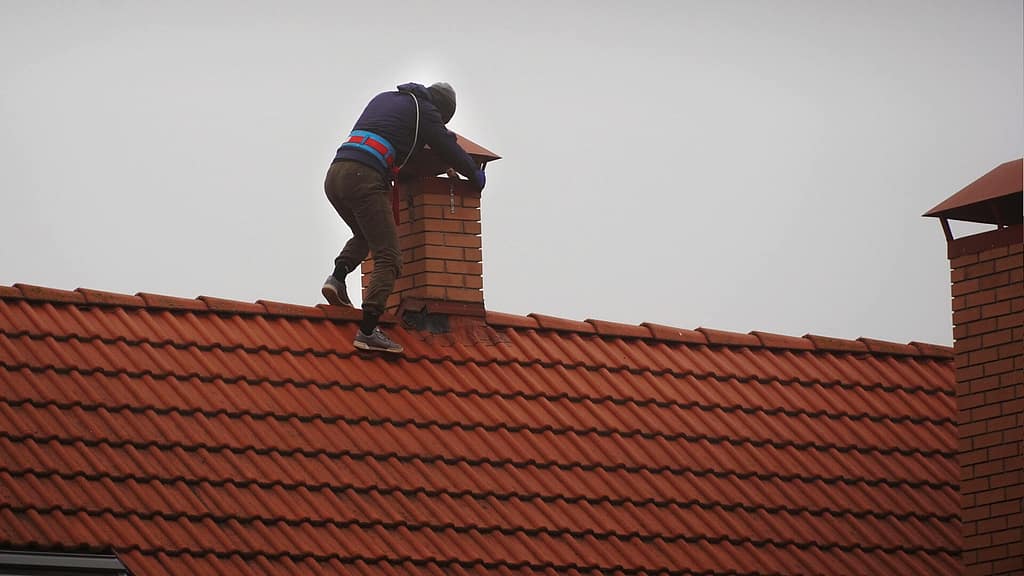 person walking on top of a tile roof