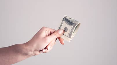 one hand holding money bills for cost estimate by Arizona roofing contractor