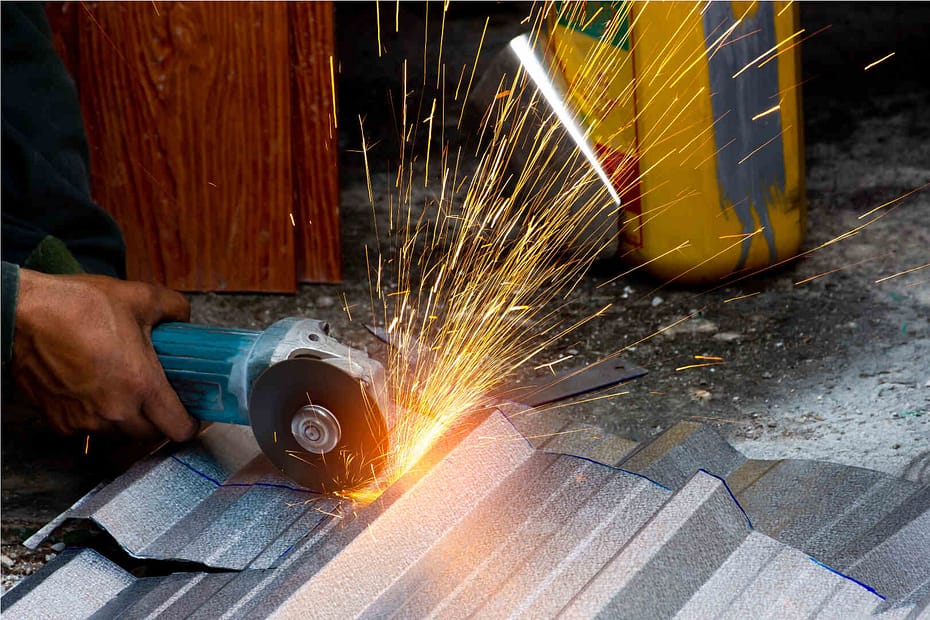 Cutting metal roof shingles with an angle grinder.