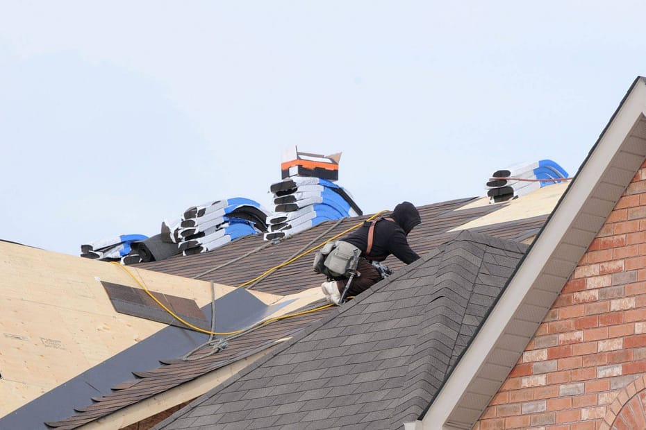 roofer using roofing squares stacked on roof
