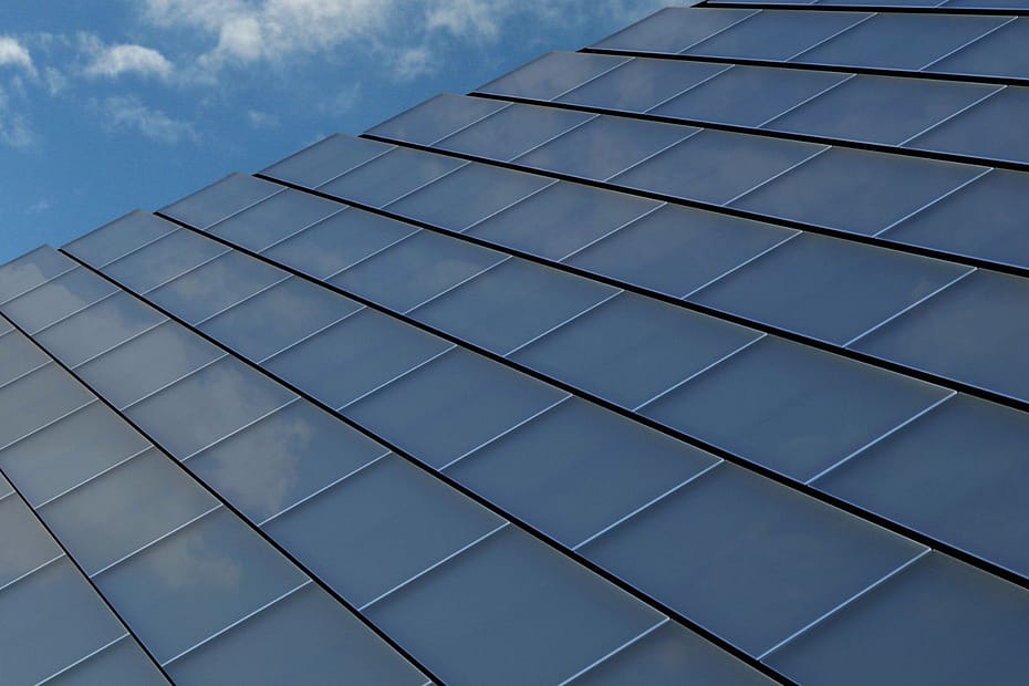 close up of solar tiles on roof against a blue sky