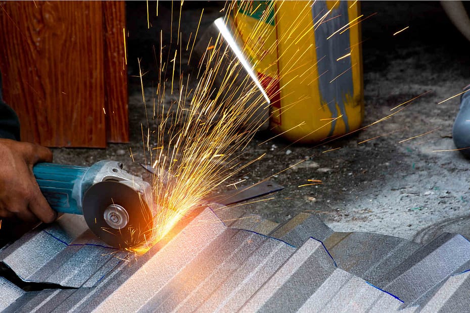 Cutting metal roof shingles with an angle grinder.