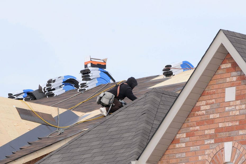 roofer using roofing squares stacked on roof