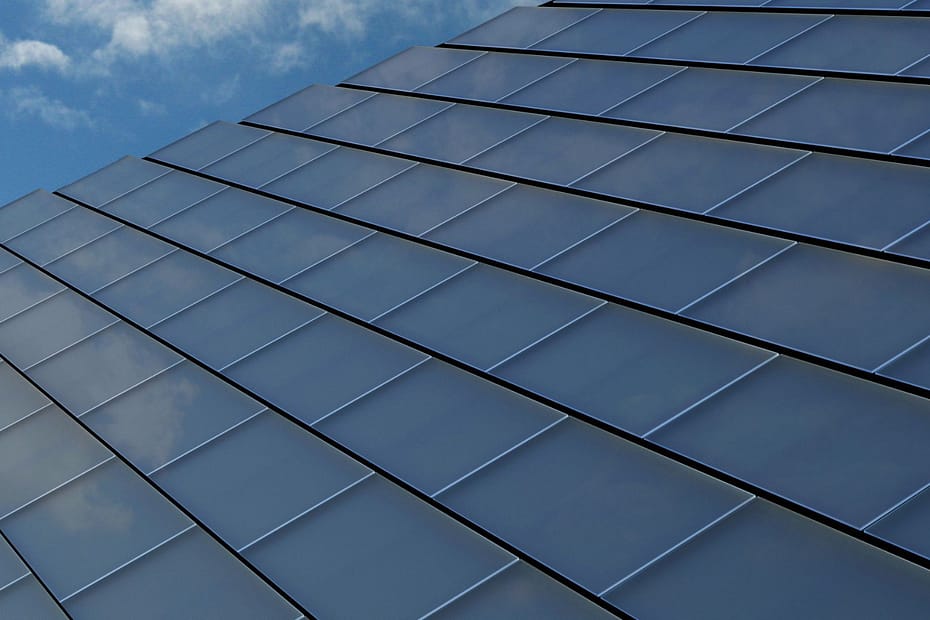 close up of solar tiles on roof against a blue sky