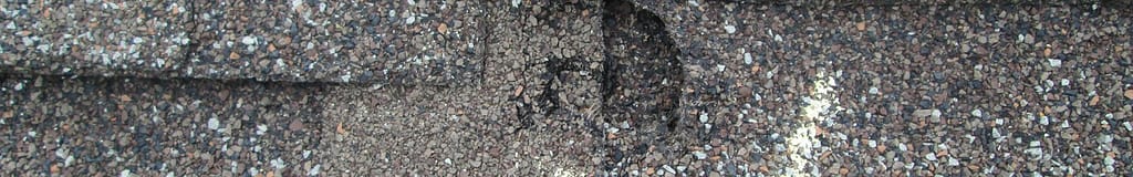 Close up of hail damage on asphalt roofing showing what hail damage looks like
