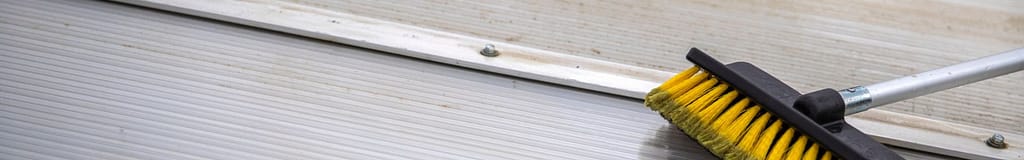 brush broom cleaning an aluminum roof