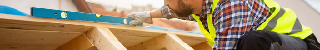 roofer measuring a roof with a level