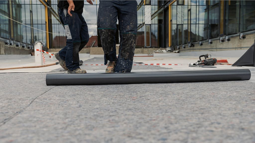 Contractors laying asphalt roll